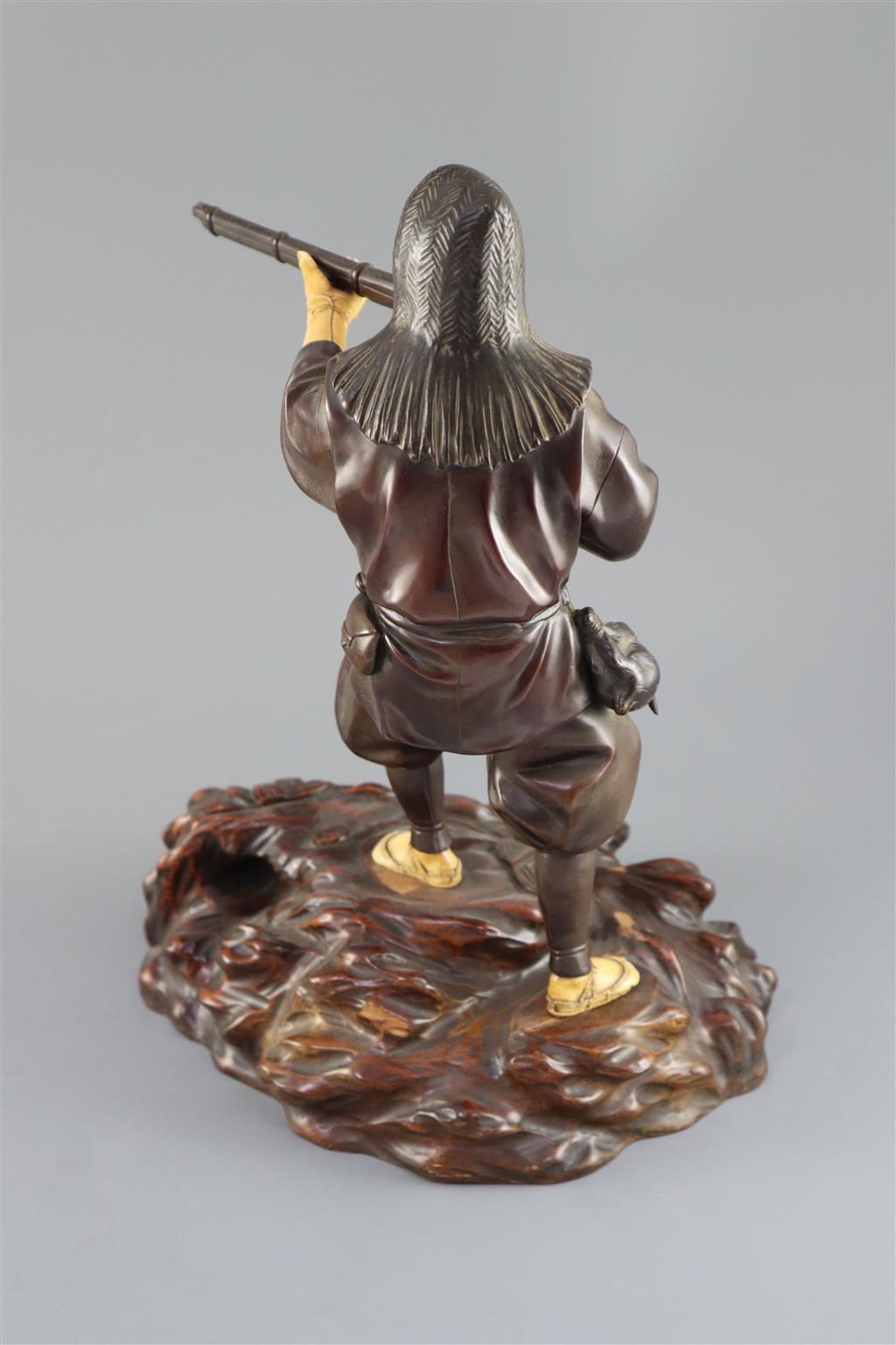 A good Japanese bronze and ivory okimono of a huntsman, Meiji period, 34cm high